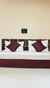 ein Bett mit vier Kissen darauf in der Unterkunft Hotel Aero View in Dabok + 17 Fotos