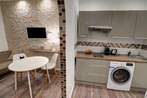 a small kitchen with a table and a washing machine at Contrast LuxApart 3 min MC Casino in Beausoleil