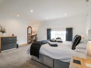 a bedroom with a large bed and a desk at Fields Farm in Draycott in the Moors