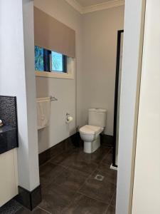 a bathroom with a toilet and a window at North Central Holiday Home in North Mackay +14 photos