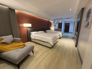 a hotel room with two beds and a couch at May Three Farm in Puerto Galera