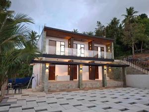 a house with a lot of windows and a patio at May Three Farm in Puerto Galera