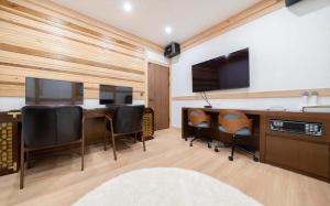 an office with a desk with chairs and a tv at Manwol Hotel Yuseong in Daejeon