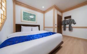a bedroom with a large white bed with blue sheets at Manwol Hotel Yuseong in Daejeon