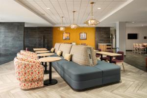 a lobby with a couch and tables and chairs at Home2 Suites By Hilton Jacksonville Airport in Jacksonville