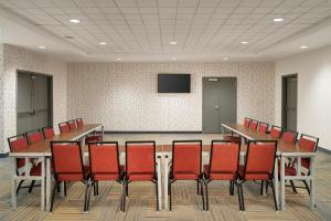 a conference room with a table and red chairs at Home2 Suites By Hilton Jacksonville Airport in Jacksonville +32 photos
