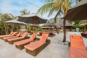 a row of chairs and umbrellas at a resort at La Joya Balangan Resort in Jimbaran