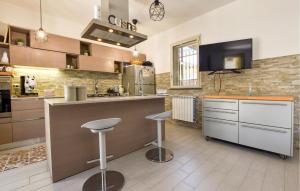 a kitchen with a counter and stools in it at Maison De Paris in San Giovanni la Punta