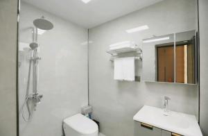 a bathroom with a toilet and a sink and a mirror at 福居乐 in Caodian