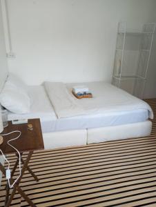a bed with white sheets and a table in a room at BN Residence in Ko Tao