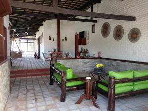 sala de estar con sofás verdes y mesa en Pousada Recanto dos Coqueiros, en Barra do Cunhau