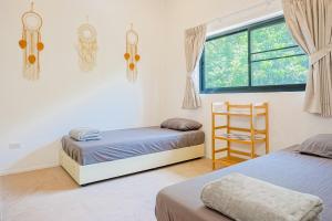 a bedroom with two beds and a chair and a window at v27 Sunset Horizon Villa Seaview in Haad Yao +56 photos