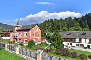 a large house with a fence in front of it at Pension Pilsachhof in Arriach