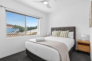 a bedroom with a large bed and a window at Ocean Spray 5 in Coffs Harbour