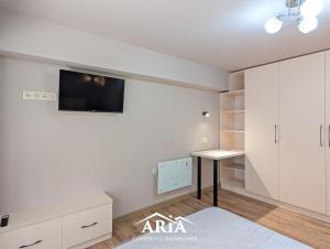 a white room with a desk and a tv on the wall at Fine Boutique Apartment in Chişinău