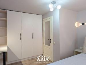 a bedroom with white cabinets and a bed at Fine Boutique Apartment in Chişinău