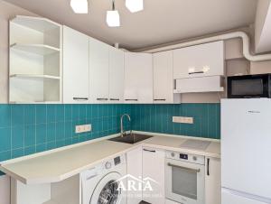 a kitchen with white cabinets and a dishwasher at Fine Boutique Apartment in Chişinău