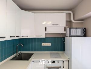 a kitchen with white cabinets and a sink at Fine Boutique Apartment in Chişinău +4 photos