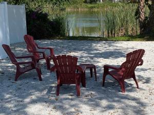 four chairs and a table in front of a pond at Beach and Boaters Delight! in Fort Myers Beach