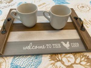 two cups on a wooden tray with welcome to the coop sign at Beach and Boaters Delight! in Fort Myers Beach