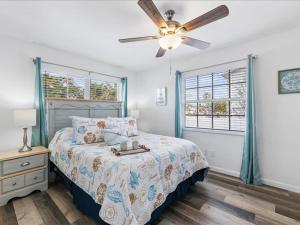 a bedroom with a bed and a ceiling fan at Beach and Boaters Delight! in Fort Myers Beach +19 photos