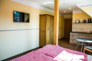 Un dormitorio con una cama y una mesa y una cocina. en Gasthaus Rundteil, en Bannewitz