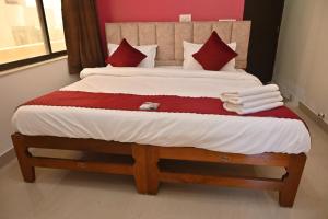 a bedroom with a large bed with red and white pillows at peaceful studio in Navi Mumbai +1 photo