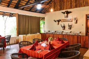 a dining room with a table and chairs and antlers on the wall at Sambiya River Lodge in Murchison Falls National Park