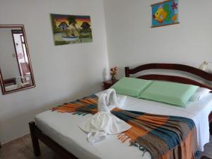 Un pat sau paturi într-o cameră la Pousada Recanto dos Coqueiros