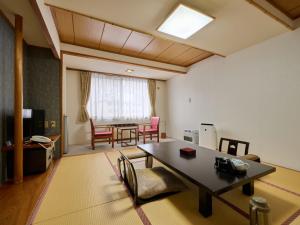 a living room with a table and a dining room at Oyado Kiyomizuya in Noboribetsu