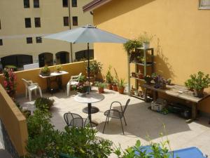 a patio area with a table, chairs and umbrella at Hotel Del Sole in Riomaggiore