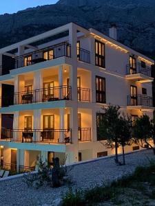 a large white building with its lights on at Baltimore.House in Baška Voda