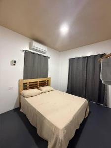 ein Schlafzimmer mit einem großen Bett und schwarzen Vorhängen in der Unterkunft Zleep Inn in San Juan