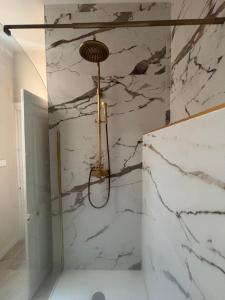 a shower in a bathroom with white marble walls at Maison Léon in Dole +8 photos