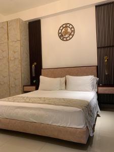 a bedroom with a large bed with a clock on the wall at Azure Luxury Apartment Luxury Stay Near Airport Negombo in Negombo +39 photos