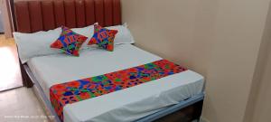 a small bed with colorful sheets and pillows at Hotel royale in Kolkata