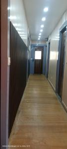 a hallway of an office building with a door and wooden floors at Hotel royale in Kolkata