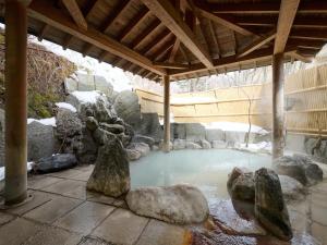 a pool of water with some rocks in it at Oyado Kiyomizuya in Noboribetsu