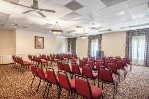 a conference room with red chairs and a podium at Clarion Inn & Suites Central Clearwater Beach in Clearwater +105 photos