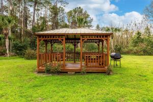 a wooden gazebo in a field with a grill at Econo Lodge Lake City-North in Lake City
