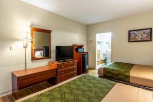 a hotel room with a bed and a flat screen tv at Econo Lodge Lake City-North in Lake City