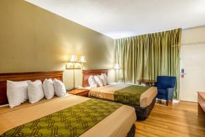 a hotel room with two beds and a chair at Econo Lodge Lake City-North in Lake City +29 photos