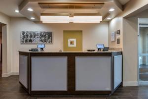 a lobby with a reception counter with two screens at Sleep Inn & Suites Kalamazoo Southwest in Kalamazoo