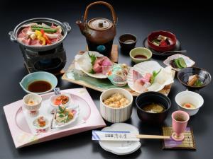 a table topped with plates and bowls of food at Oyado Kiyomizuya in Noboribetsu