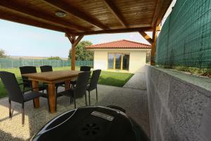 a patio with a wooden table and chairs at Villa Dudinka in Dudince
