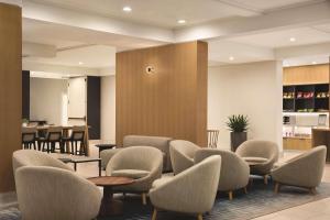 a waiting room with chairs and tables at Radisson Hotel Seattle Airport in SeaTac