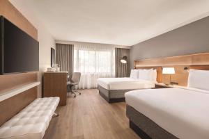 a hotel room with two beds and a desk at Radisson Hotel Seattle Airport in SeaTac