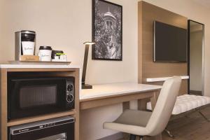 a room with a desk with a microwave and a chair at Radisson Hotel Seattle Airport in SeaTac