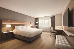 a hotel room with a bed and a desk at Radisson Hotel Seattle Airport in SeaTac +53 photos