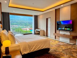 a bedroom with a large bed with a flat screen tv at Cahaya Villa Garut in Garut
